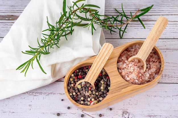 Wooden double spices cellar with pepper and himalayan salt with rosemary and white napkin