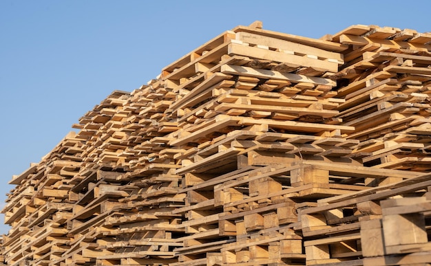 Wooden euro pallets for transfering goods to customers Used wooden pallets in stack in the warehouse Wooden pallet overlap