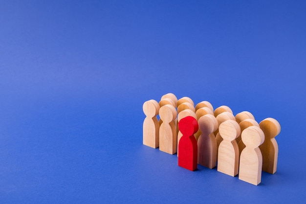 Wooden faceless figures of employees standing behind their leader