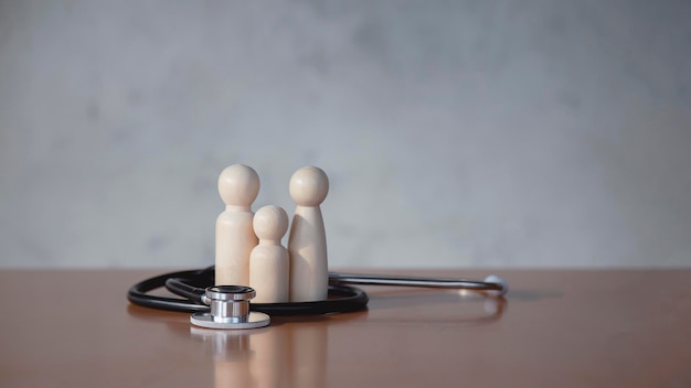 Wooden family sign on gray background and stethoscope, health insurance concept