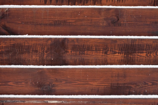 Wooden fence background with snow lying on the boards