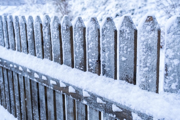 Wooden fence covered with a lot of snow winter in the village cold christmas mood