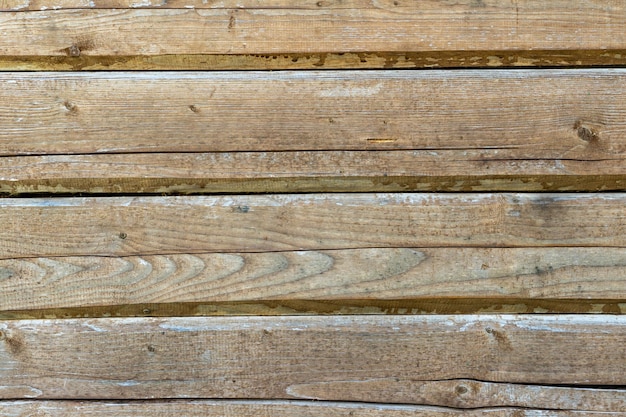 A wooden fence or a wall with a pronounced knotty texture a natural background of unpainted wood with a rough surface Blank wooden background for design or text insertion