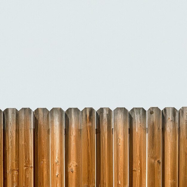 Photo a wooden fence with a clear blue sky behind it