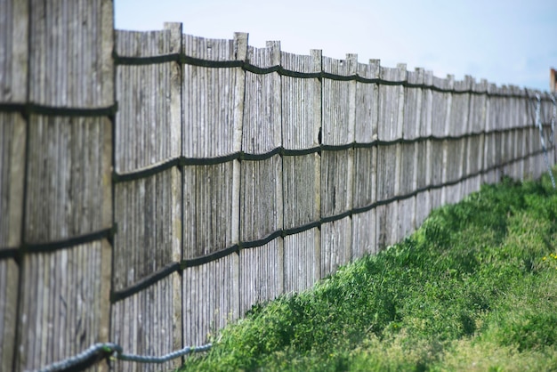 Photo a wooden fence with a rope fence in the grass.