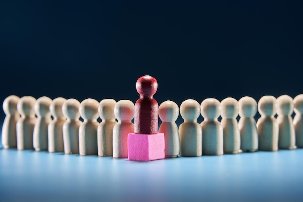 Wooden figures as a group and red figurine as leader