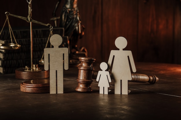 Wooden figures of family with child and gavel on a table