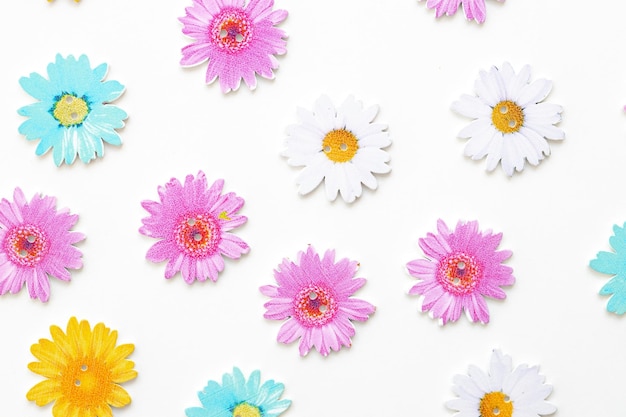 Wooden figures in the form of colored flowers on a white background