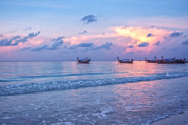 Wooden fishing boats on the sea beach in the morning sunrise