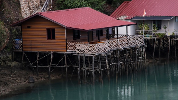 Wooden floating village at the edge of the river with blue water