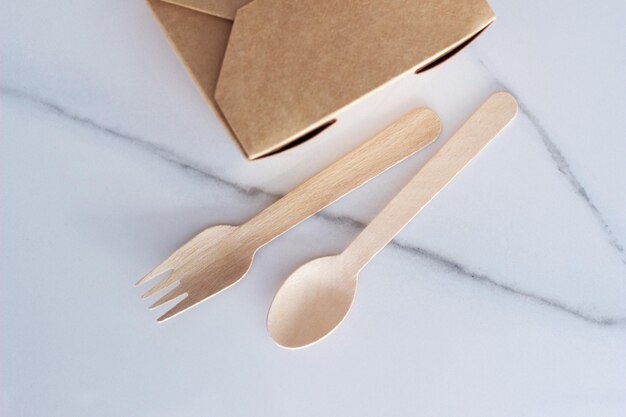 Wooden fork spoon and brown craft paper food container Recycling ecofriendly ecology zero waste