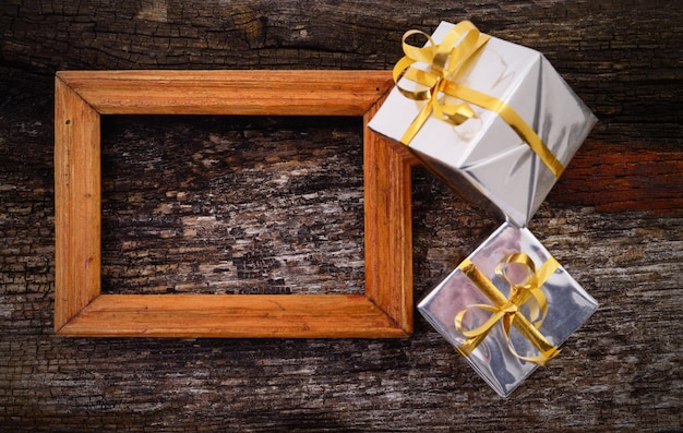 Wooden frame and gift boxes on wood table background