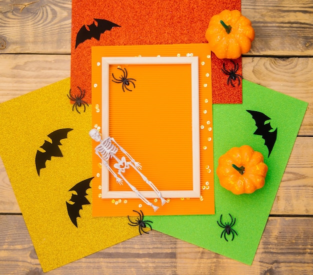 Wooden frame with pumpkin skeleton spiders and bats on a wooden background A festive Halloween theme Empty space for text