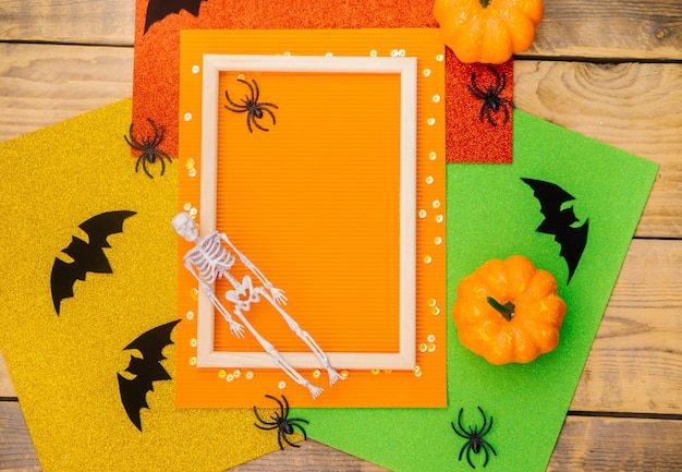 Wooden frame with pumpkin skeleton spiders and bats on a wooden background A festive Halloween theme Empty space for text