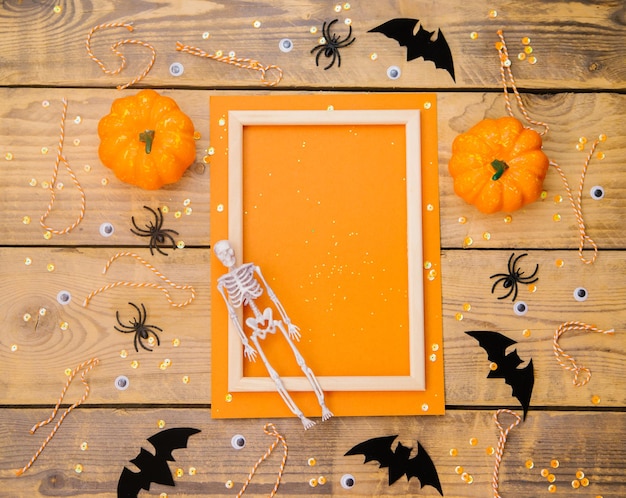 Wooden frame with pumpkin skeleton spiders and bats on a wooden background A festive Halloween theme Empty space for text