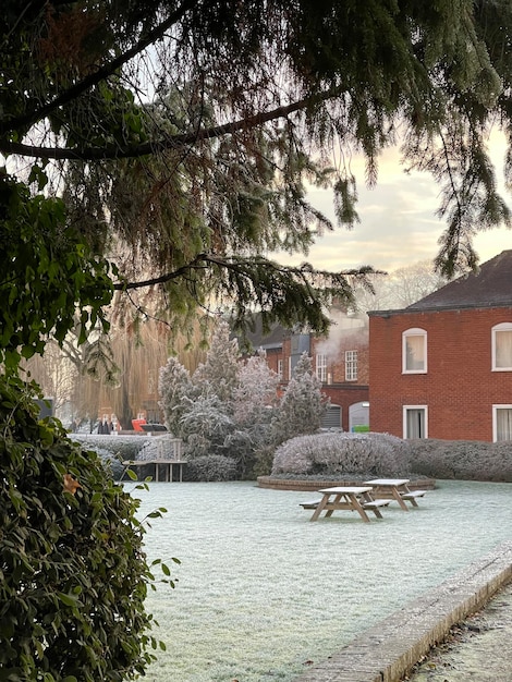 Wooden garden tables in the yard of apartment building on a cold winter frosty morning