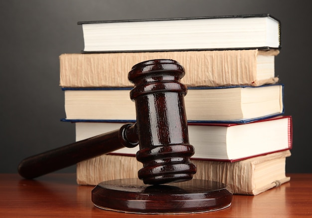 Photo wooden gavel and books on grey surface