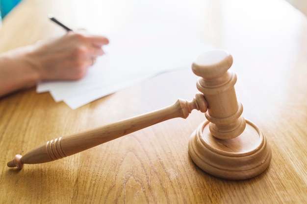 Wooden gavel in front of judge writing on document