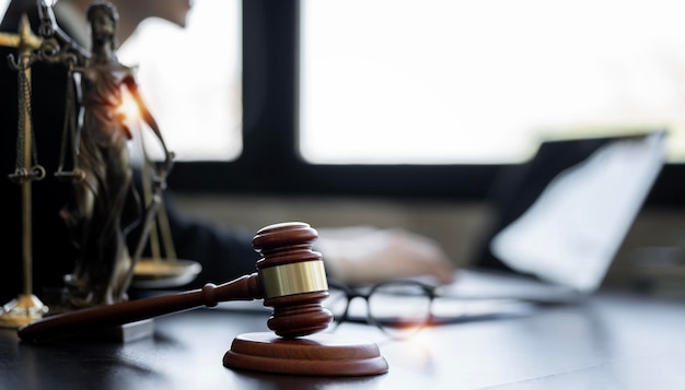 Wooden gavel on the table Female lawyer working in office Law and justice concept