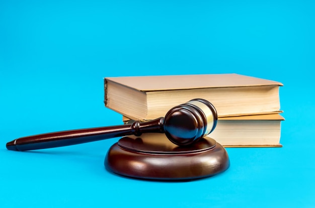 Wooden gavel with books on a blue background Justice concept