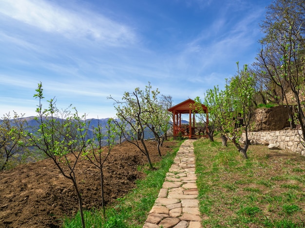 Wooden gazebo in the alpine garden in spring.