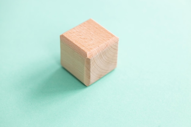 Wooden geometric shapes cube isolated on a blue