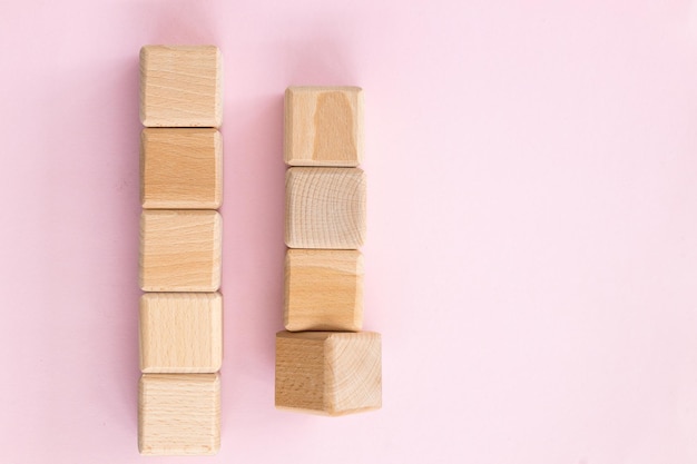 Wooden geometric shapes cubes isolated on a pink background