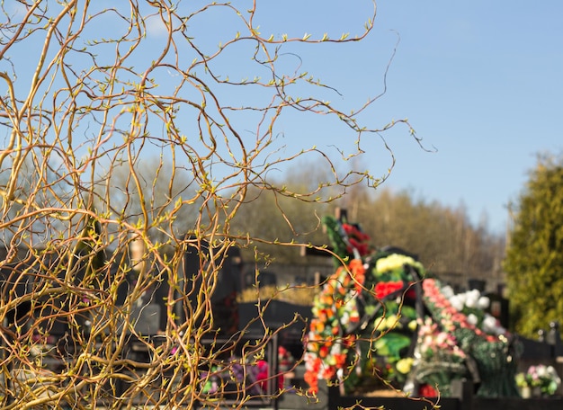 Wooden grave cross with artificial flowers at sunset Orthodox traditional cemetery