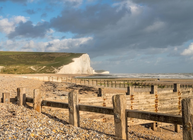 Photo wooden groynes frame the white cliffs of seven sisters