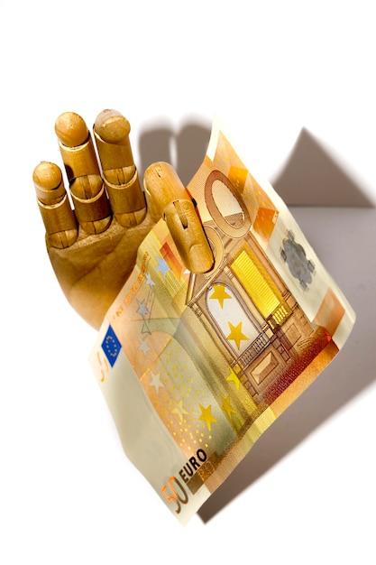 Wooden hand holding euro currency