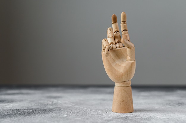 Photo the wooden hand shows two raised fingers. the concept of communication.