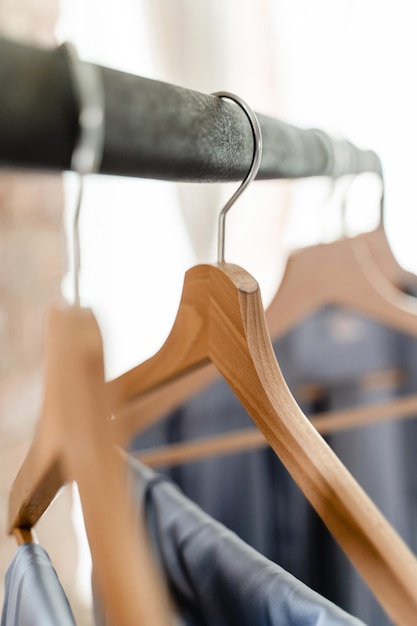 Wooden hangers with different outfits in the wardrobe