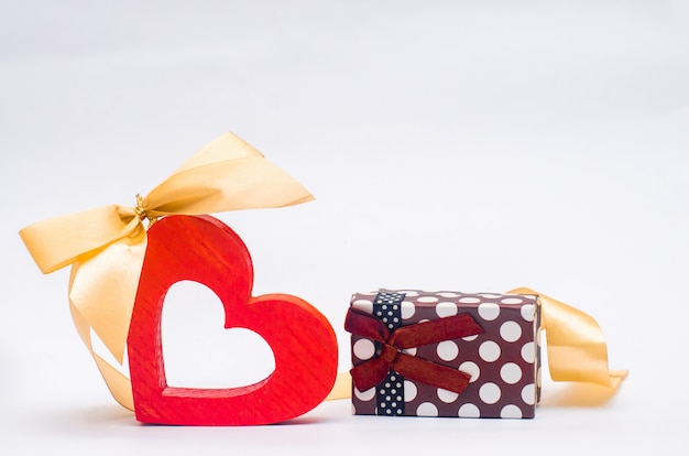 Wooden heart with bow and gift on white background. Valentine's Day