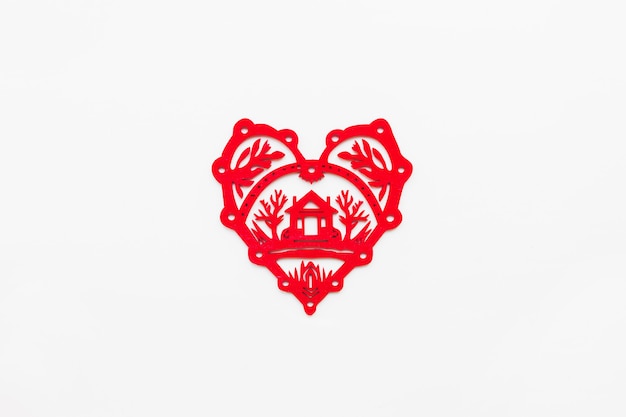 Wooden heart with silhouette of house. Ornamental red Christmas decoration. 