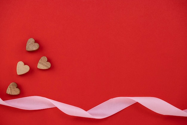 Wooden hearts on red background with copy space