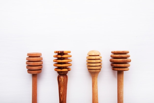 wooden honey stick isolated on white wooden background