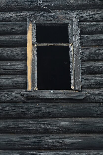 Wooden house after the fire. Coals on the logs. The ashes of the house from the fire. Burnt destroyed cottage.