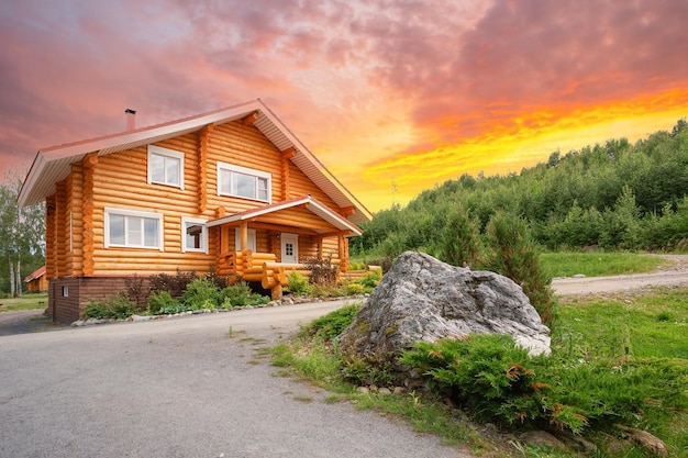 Wooden house on the lawn with stone under the dramatic sky