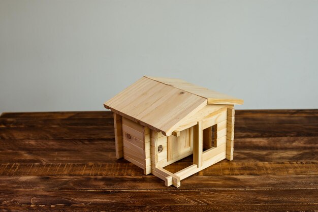 Wooden house model over old table on white background Top view