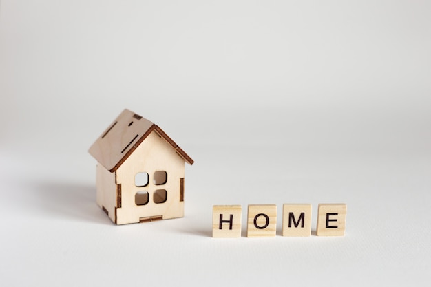 Wooden house model and wooden letters with the inscription Home