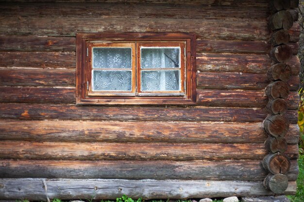 Wooden house old log cabin the window in the wall logs stacked in a row