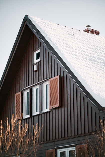 Wooden house roof covered with snow Concept of Christmas holidays spent at home