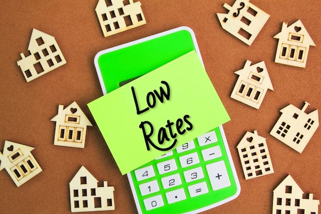 wooden house shape calculator and colored paper with the word LOW RATES