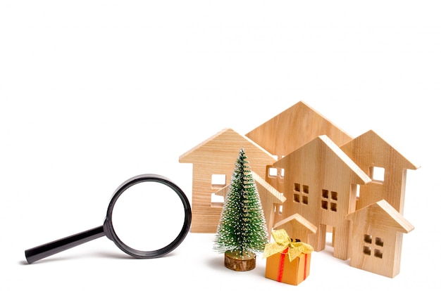 Wooden houses and Christmas tree and magnifying glass. 