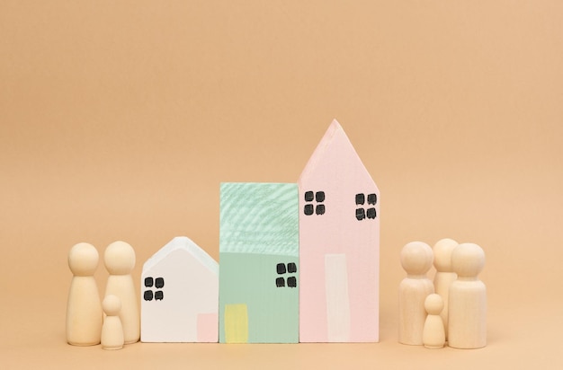 Wooden houses and wooden men of a family with children Concept of searching for rental housing