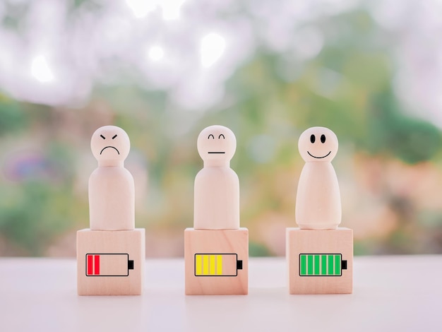 Photo wooden human figure and status of battery charging with emotion face level