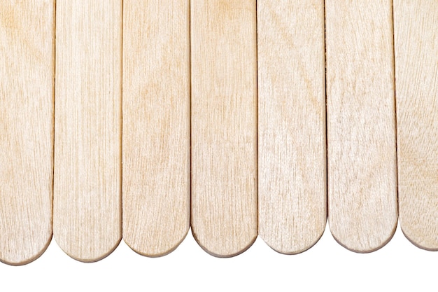 Wooden ice cream sticks laid out in row isolated on white background with clipping path