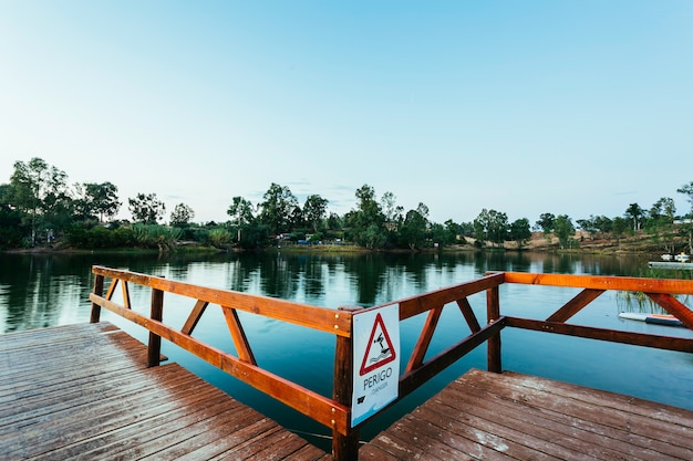 Wooden jetty with danger sign jumping into the water