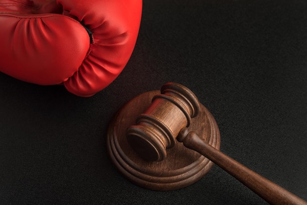 Wooden judge gavel and Boxing glove Sports suits Confrontation in court