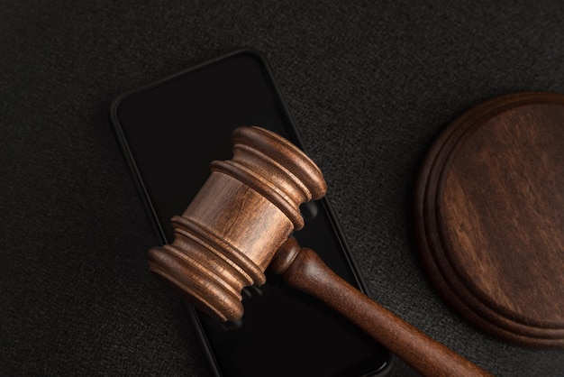 Wooden judge gavel on the smartphone Court decision Rights holders